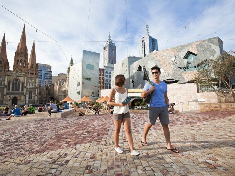 Couple walking through Federation Square, Melbourne